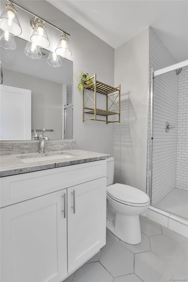 full bath featuring tile patterned floors, a stall shower, toilet, and vanity