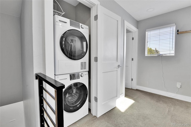 washroom featuring baseboards, carpet, laundry area, and stacked washing maching and dryer