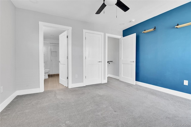 unfurnished bedroom featuring ensuite bath, baseboards, carpet, and a ceiling fan