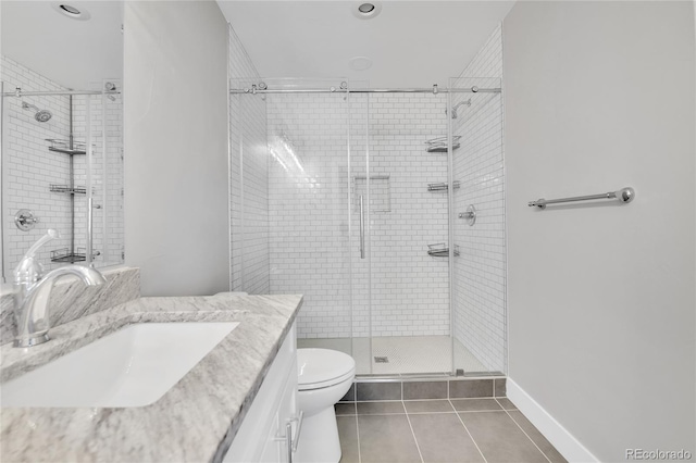 bathroom featuring vanity, a shower stall, toilet, and tile patterned floors