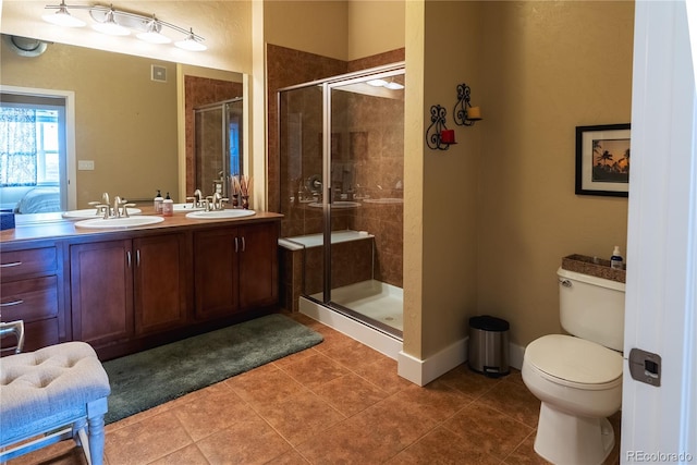 bathroom featuring tile patterned floors, vanity, toilet, and a shower with shower door