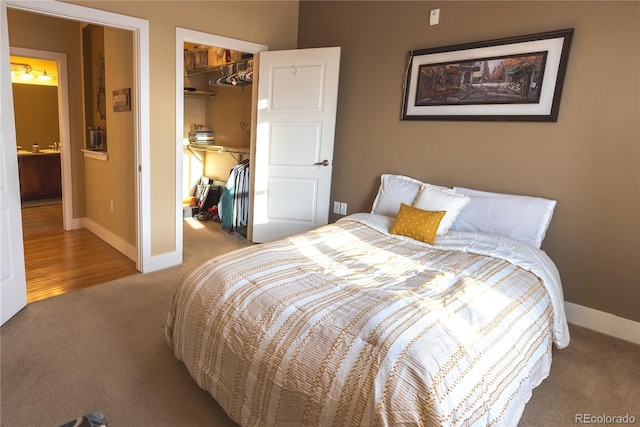 carpeted bedroom with a spacious closet and a closet