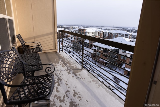 view of snow covered back of property