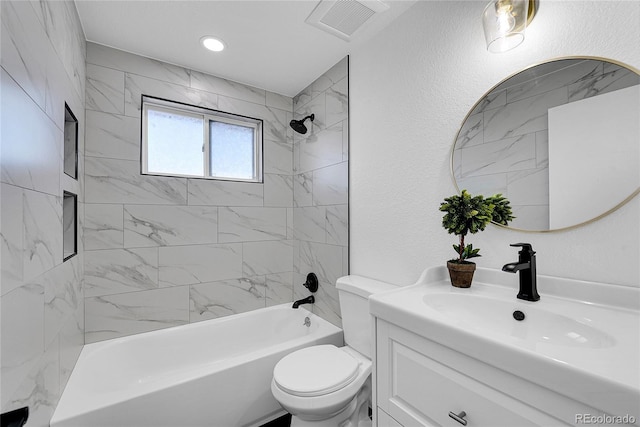 full bathroom with toilet, vanity, and tiled shower / bath