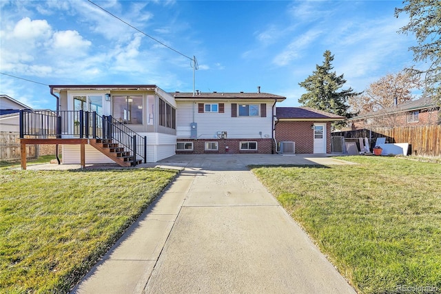 view of front facade with a patio area, central AC, and a front lawn