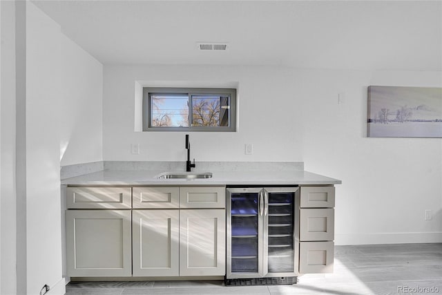 bar featuring sink, gray cabinets, and wine cooler