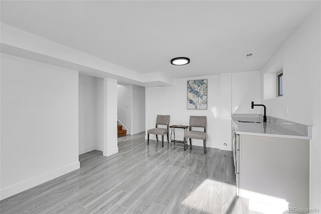 sitting room featuring sink and light wood-type flooring