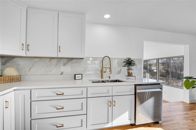 kitchen featuring light hardwood / wood-style flooring, tasteful backsplash, dishwasher, white cabinets, and sink