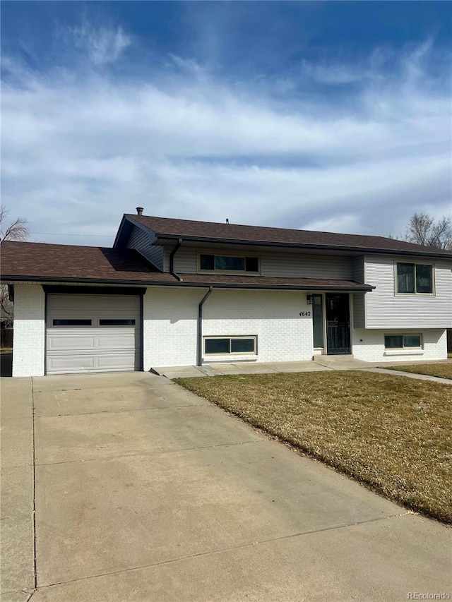 view of front facade with concrete driveway, an attached garage, and brick siding