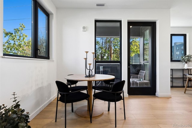 1601 Park Ave Unit 216, Denver, CO 80218 - dining space with healthy amount of natural light, light wood-type flooring, and baseboards