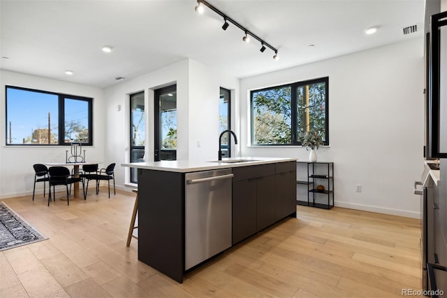 1601 Park Ave Unit 216, Denver, CO 80218 - kitchen featuring dishwasher, a center island with sink, a sink, plenty of natural light, and recessed lighting