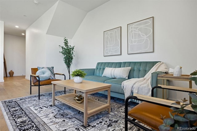 living room featuring light wood-type flooring and vaulted ceiling