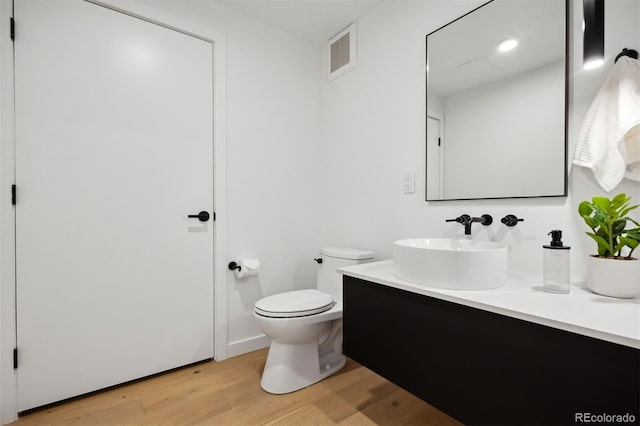 bathroom featuring hardwood / wood-style floors, vanity, and toilet