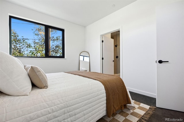 bedroom with dark carpet and multiple windows