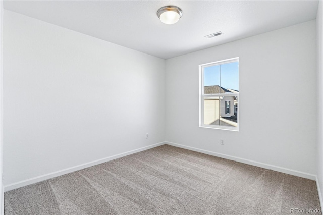 carpeted spare room featuring visible vents and baseboards