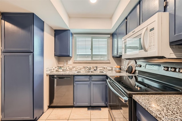 kitchen with dishwasher, black electric range, sink, light tile patterned floors, and light stone counters