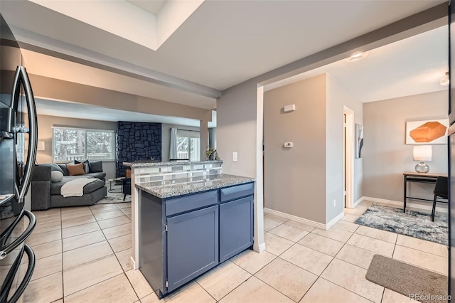 kitchen featuring black refrigerator with ice dispenser, blue cabinets, kitchen peninsula, and light tile patterned floors