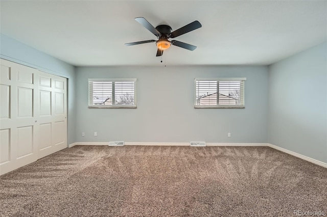 unfurnished bedroom with a closet, ceiling fan, and carpet flooring