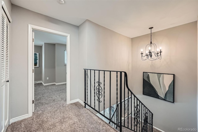 hallway featuring carpet flooring and an inviting chandelier