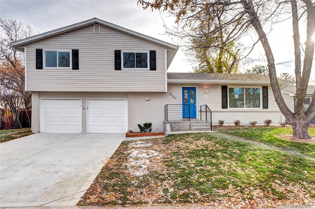 split level home with a garage and a front lawn