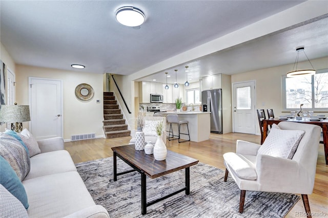 living room with light wood-type flooring and sink