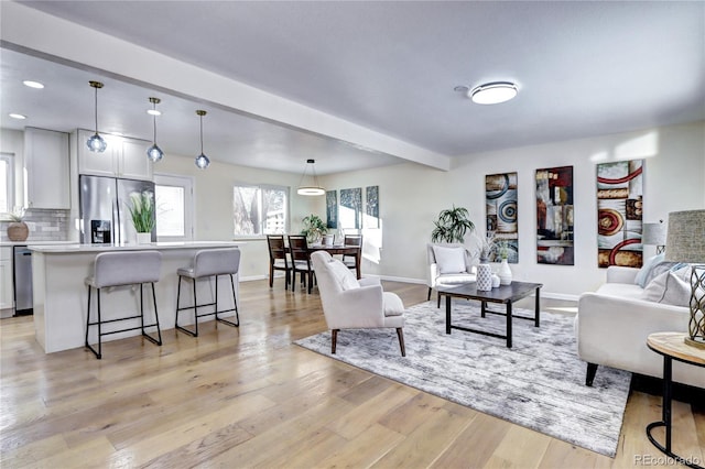 living room with light hardwood / wood-style flooring and beamed ceiling