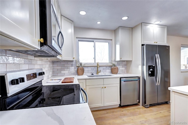 kitchen with stainless steel appliances, white cabinetry, a wealth of natural light, and sink