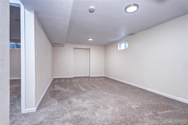 basement featuring carpet and a textured ceiling