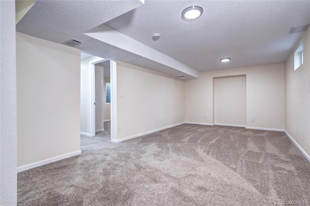 basement featuring carpet floors and a textured ceiling