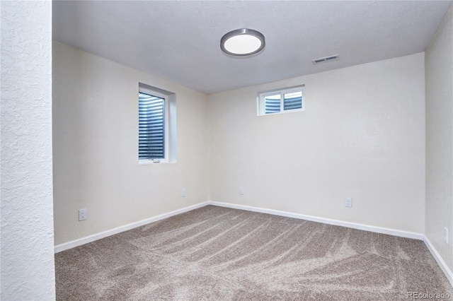 basement with carpet and a textured ceiling