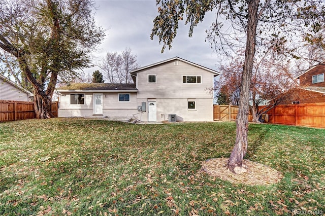 back of property featuring a lawn and central AC unit