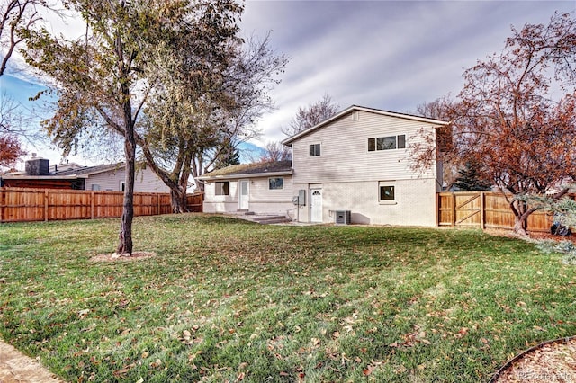 rear view of property with a yard and central AC