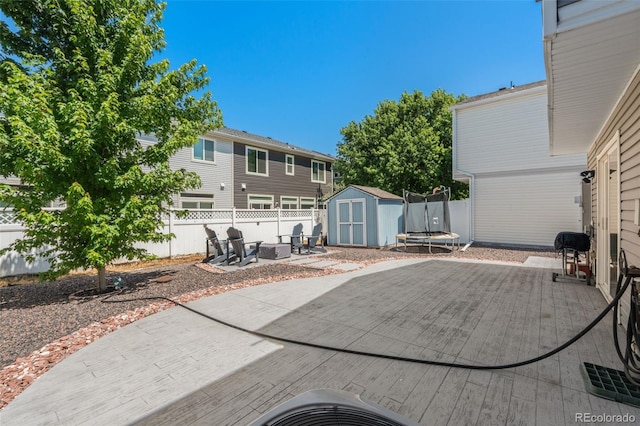 4695 Andes St, Denver, CO 80249 - fenced backyard with a storage shed, a patio area, a trampoline, and an outdoor fire pit