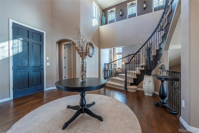 foyer entrance featuring dark hardwood / wood-style flooring and a towering ceiling