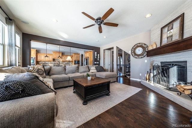 living room featuring ceiling fan and dark hardwood / wood-style flooring