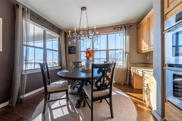 dining space with hardwood / wood-style flooring and an inviting chandelier