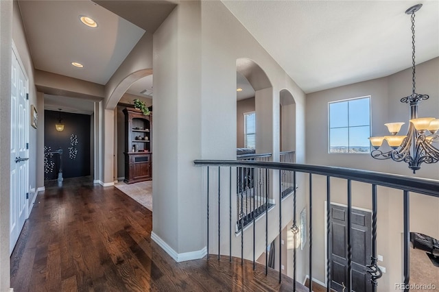 corridor featuring dark hardwood / wood-style floors and a notable chandelier