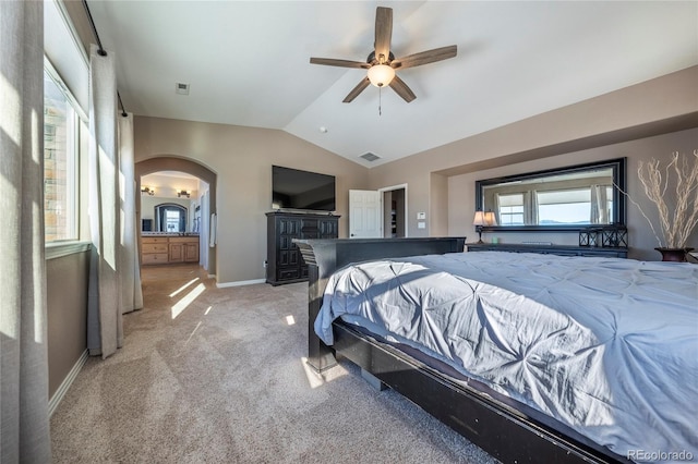 carpeted bedroom with ensuite bathroom, vaulted ceiling, and ceiling fan