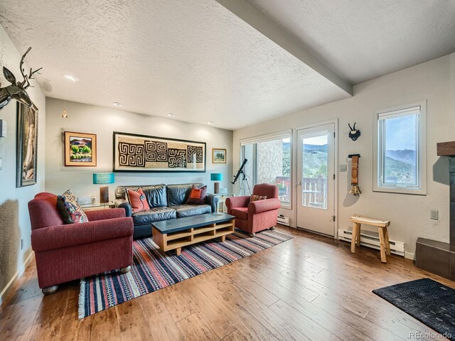 1370 Sandstone Dr Unit 12, Vail, CO 81657 - living room featuring baseboard heating, a textured ceiling, hardwood / wood-style flooring, and recessed lighting
