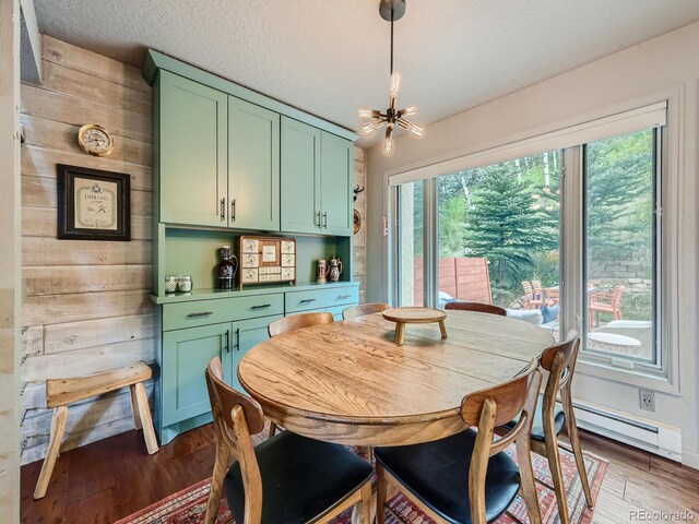 1370 Sandstone Dr Unit 12, Vail, CO 81657 - dining room featuring a baseboard radiator, dark wood-style flooring, and a chandelier