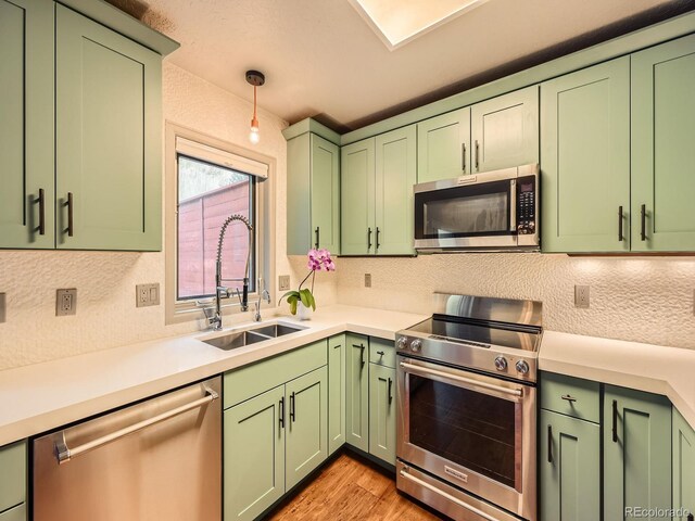 1370 Sandstone Dr Unit 12, Vail, CO 81657 - kitchen featuring appliances with stainless steel finishes, green cabinets, light countertops, light wood-style floors, and a textured wall