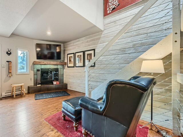 1370 Sandstone Dr Unit 12, Vail, CO 81657 - living area featuring wood finished floors, a fireplace, a baseboard radiator, stairway, and wooden walls