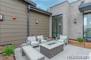 view of patio with an outdoor living space with a fire pit