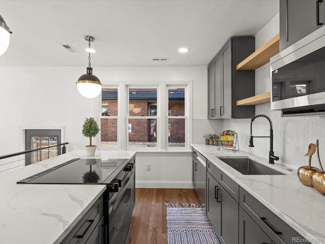 kitchen with appliances with stainless steel finishes, sink, gray cabinetry, and light stone counters