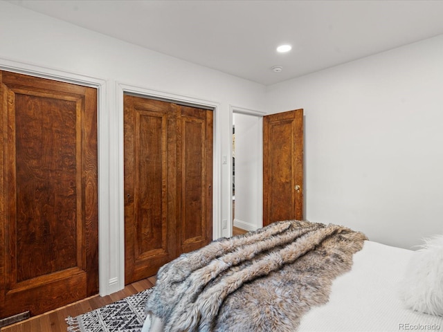 bedroom featuring hardwood / wood-style flooring and multiple closets