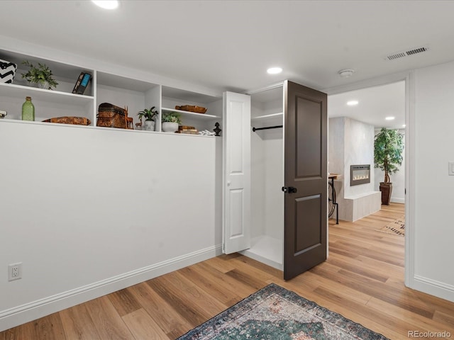 interior space featuring light hardwood / wood-style flooring and a large fireplace