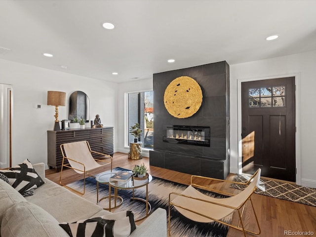 living room with wood-type flooring and a tile fireplace