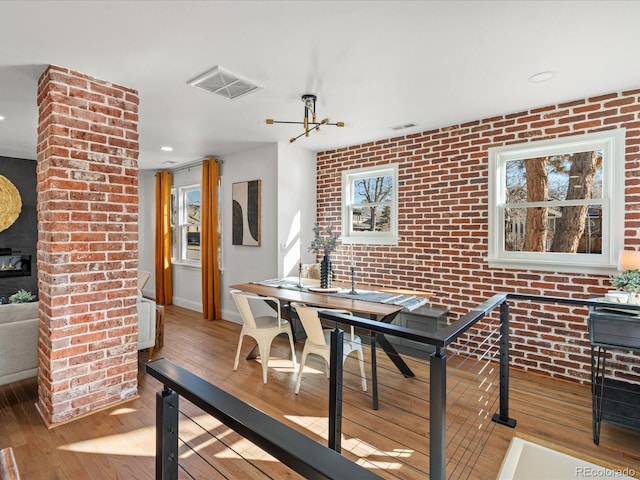 dining room featuring light hardwood / wood-style flooring and brick wall