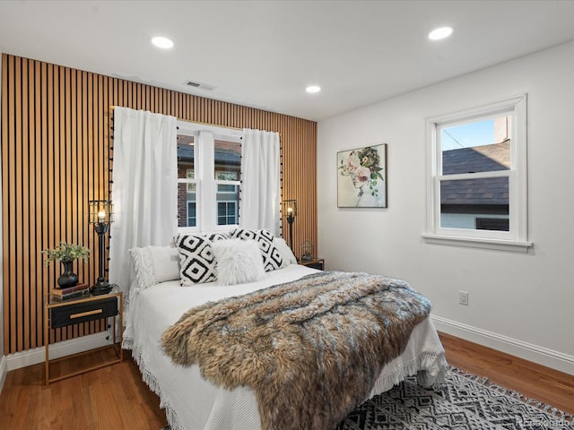 bedroom featuring multiple windows and hardwood / wood-style floors