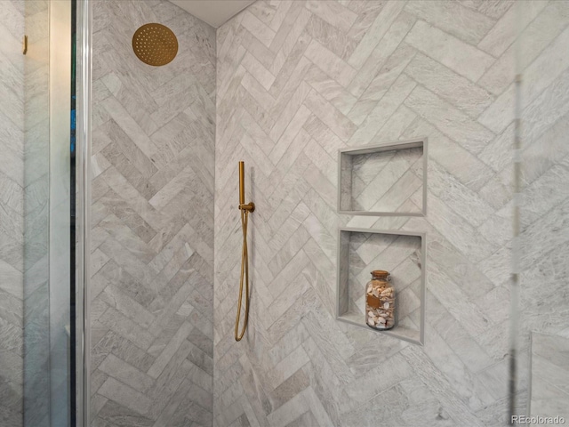 interior details featuring a tile shower